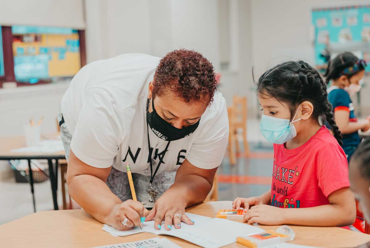 Claremont Academy teacher helping student in class