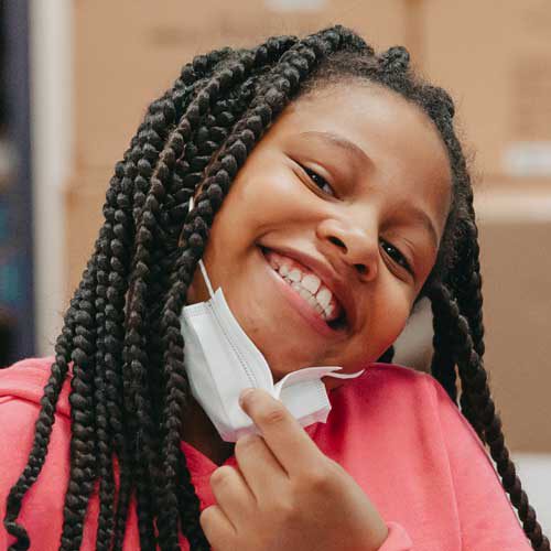 Claremont student smiling at camera with mask